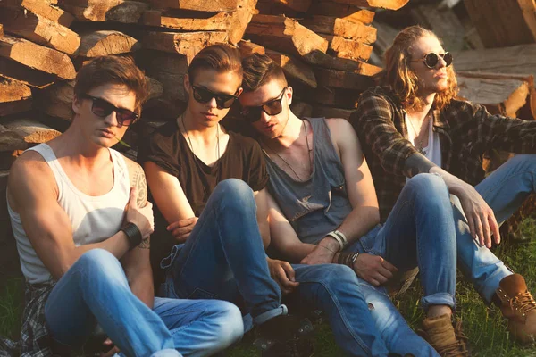 Mode Jungs Freunde sitzen auf dem Gras, Holz Hintergründe, Sonne — Stockfoto