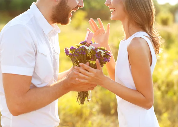 Мужчина делает на природе помолвку с девушкой, сюрприз, эмоция, улыбка — стоковое фото