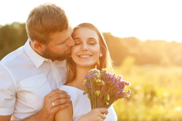 Pareja en el amor en la naturaleza, el chico besa a la chica en la mejilla —  Fotos de Stock