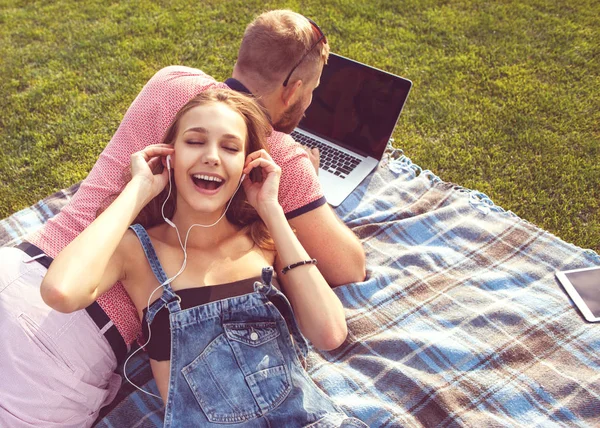 Couple amoureux assis sur l'herbe en vacances près de l'ordinateur — Photo