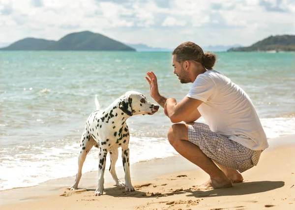 Homem com cão na praia tropical — Fotografia de Stock