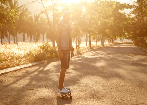 Un tipo alla hipster. Uomo di moda sul palmo della strada al tramonto — Foto Stock
