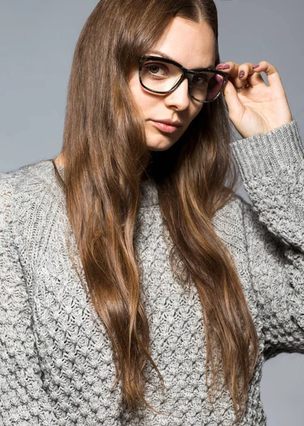Chica de moda sobre un fondo gris en el estudio posando con vidrio —  Fotos de Stock