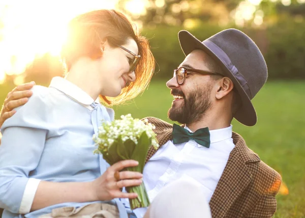 Pár v lásce v přírodě objímání s květinami na svatého Valentýna — Stock fotografie