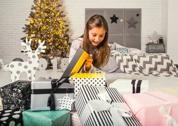 Little girl at christmas opens gifts — Stock Photo, Image