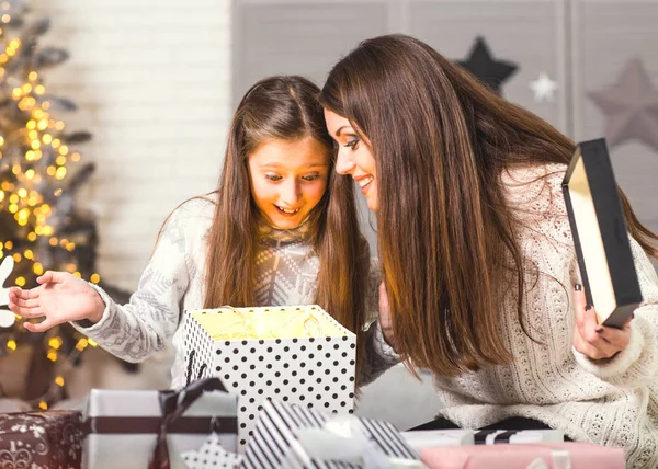 Молодая мать и ее маленькие дочери открывают волшебное Рождество — стоковое фото