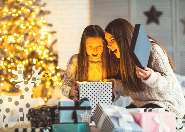 Młoda matka i córki zadumany, otwierając magiczne święta! — Zdjęcie stockowe