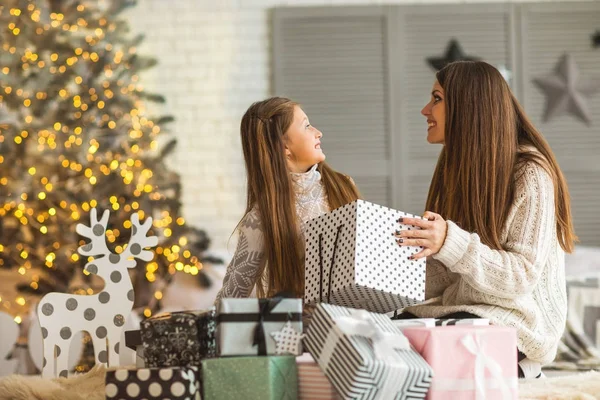 Мать и дочь на Рождество дома на елку давая e — стоковое фото