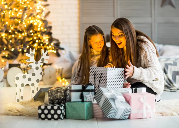 Ung mamma och döttrarna ittle öppna en magisk jul — Stockfoto