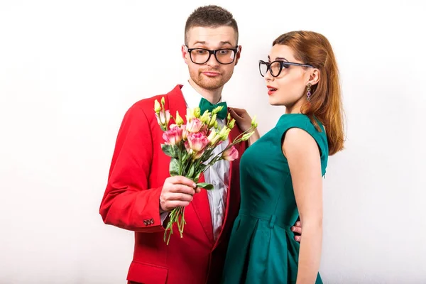 Hipster couple in love with a bouquet of flowers in the studio a — Stock Photo, Image