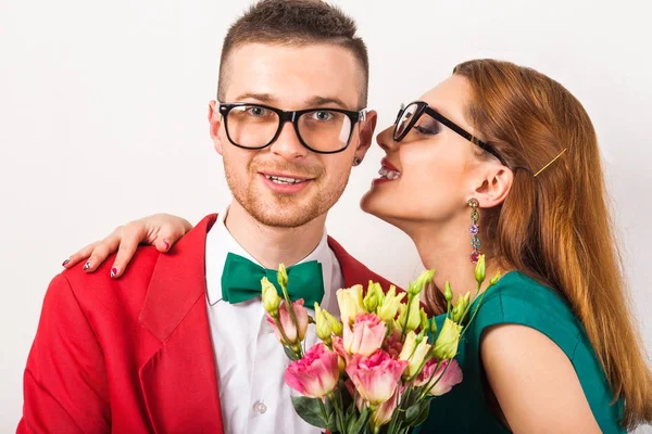 Hipster par i kärlek med en bukett blommor i studio ett — Stockfoto