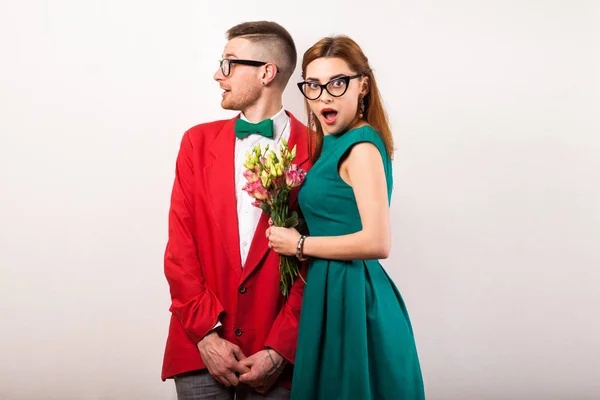 Hipster couple in love with a bouquet of flowers in the studio a — Stock Photo, Image