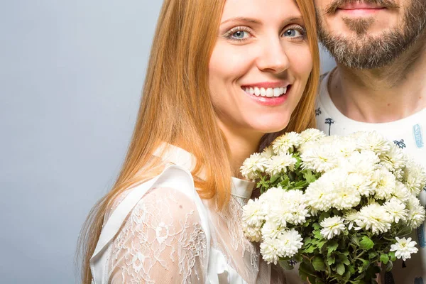 Fashion couple in love with a white bouquet of color in the stud — Stock Photo, Image