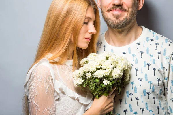 Fashion couple in love with a white bouquet of color in the stud — Stock Photo, Image