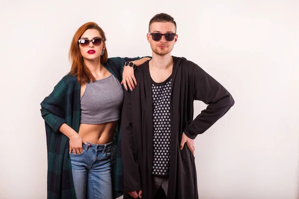 Hermosa pareja de moda con gafas de sol sobre un fondo blanco . — Foto de Stock