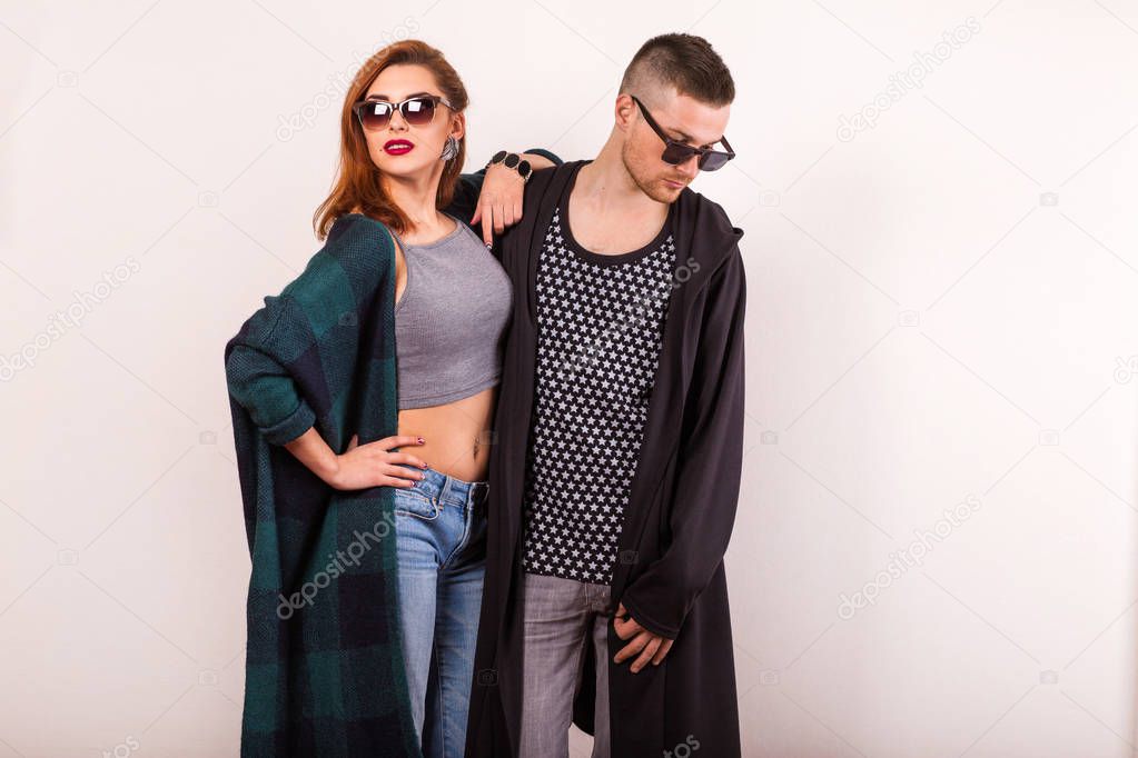 beautiful fashion couple with sunglasses on a white background. 