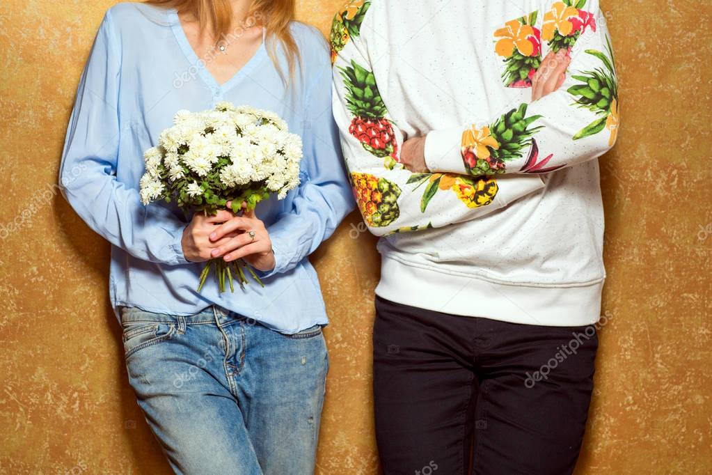 hipster couple in love with a bouquet of flowers in the studio, 