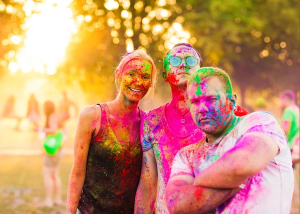 Guys with a girl celebrate holi festival — Stock Photo, Image