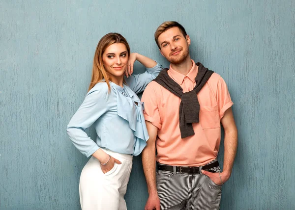 Chica de moda y chico en ropa de salida posando en un backgrou azul — Foto de Stock