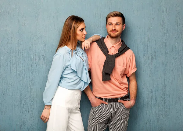 Chica de moda y chico en ropa de salida posando en un backgrou azul — Foto de Stock