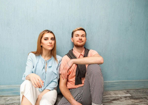 Chica de moda y chico en ropa de salida posando en un backgrou azul — Foto de Stock