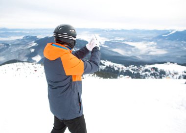 turist kayakçı miğfer, zaferleri ile mutlu bir dağın zirvesinde