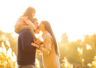 Aile eğleniyor sonbahar parkta oynarken kisses