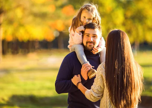 Familj spelar i höstens park att ha kul på sunset — Stockfoto