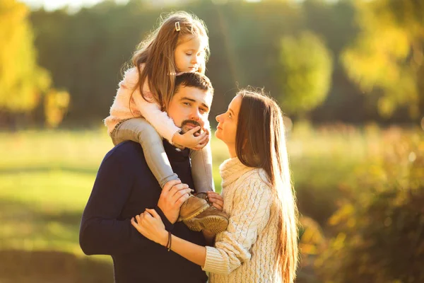 Família brincando no parque de outono se divertindo ao pôr do sol — Fotografia de Stock