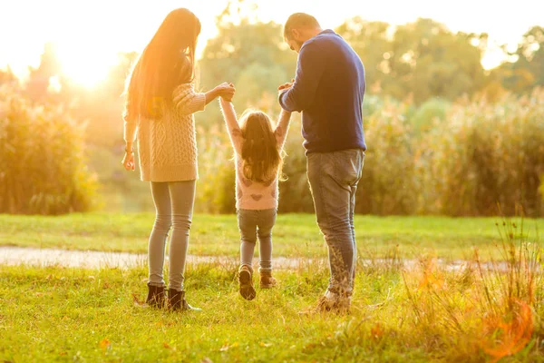 Familienspaziergang im Park, glücklich bei Sonnenuntergang — Stockfoto