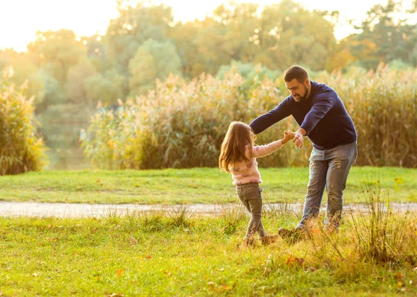Dad and daughter in the autumn park play laughing — Stock Photo, Image