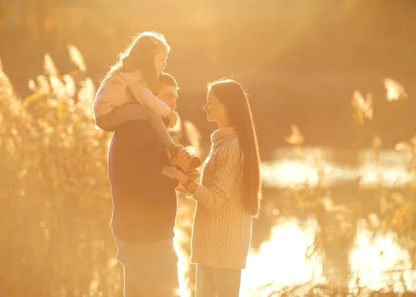 Famille jouant dans le parc d'automne s'amuser au coucher du soleil — Photo