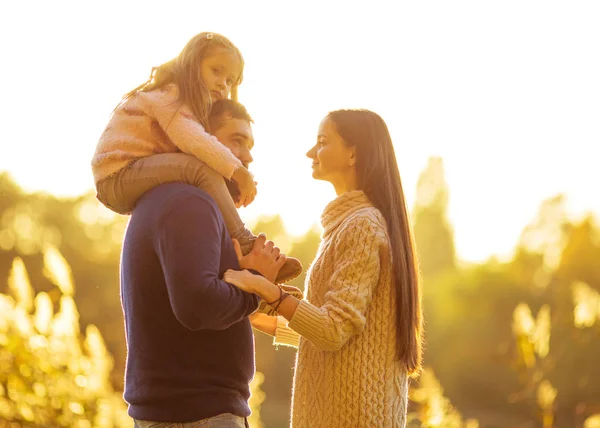 Familj spelar i höstens park att ha kul på sunset — Stockfoto