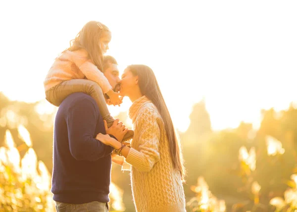 Family playing in autumn park having fun kisses — Stock Photo, Image