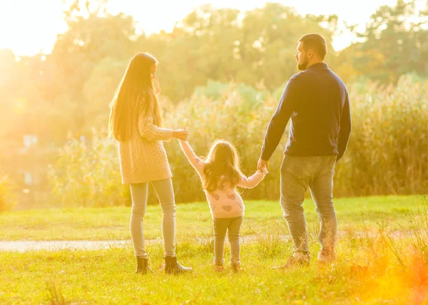 Família brincando no parque de outono se divertindo ao pôr do sol — Fotografia de Stock