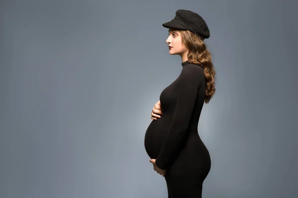 Schöne modische Mädchen schwanger im Studio steht posiert — Stockfoto