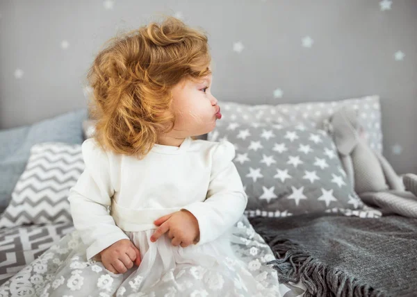 Kislány ül az ágyon a vele játék — Stock Fotó