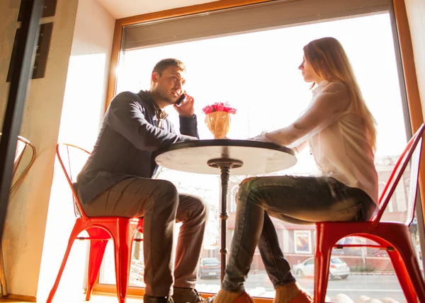 Guy with a girl in a cafe on St. Valentine's Day, a guy gives a — Stock Photo, Image