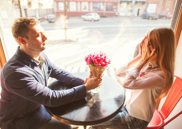 Tipo con una chica en un café en el Día de San Valentín, un chico da un —  Fotos de Stock