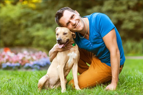 Killen med sin hund som kramas i parken — Stockfoto