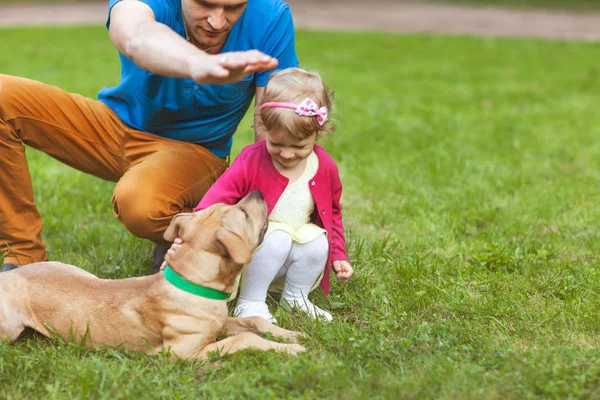 Papa avec sa fille jouant dans le parc avec son chien — Photo