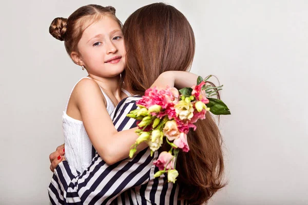 娘がスタジオで彼女の母の花を与える幸せな母の日 — ストック写真