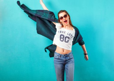 Studio duygusal gülümseyen güneş gözlüğü turkuaz arka plan yakınındaki kız moda. Vogue stili