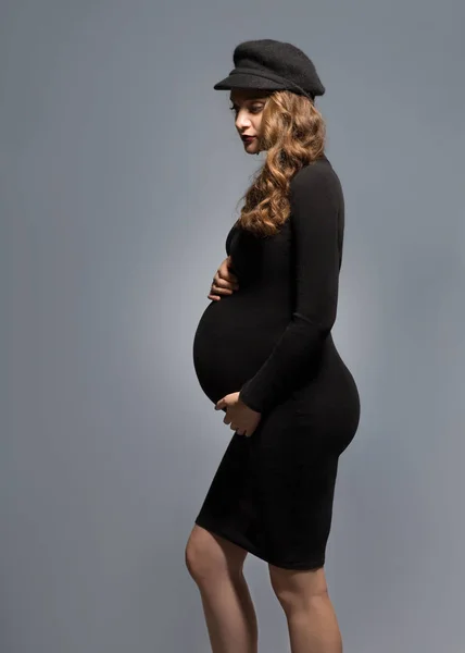 Vackra fashionabla flicka gravid i studio står poserar — Stockfoto