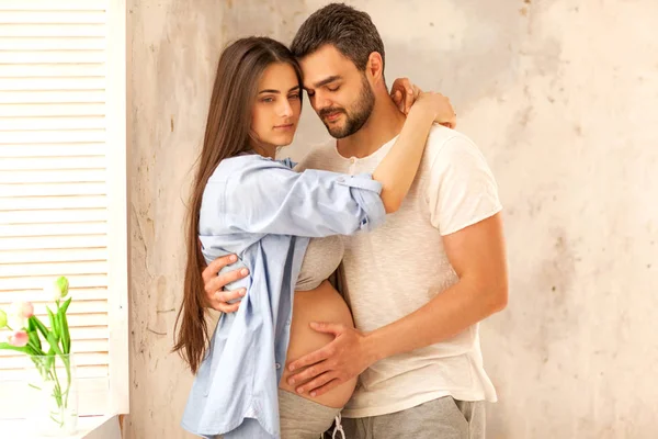 Casal apaixonado grávida abraçando, esperando pelo bebê — Fotografia de Stock