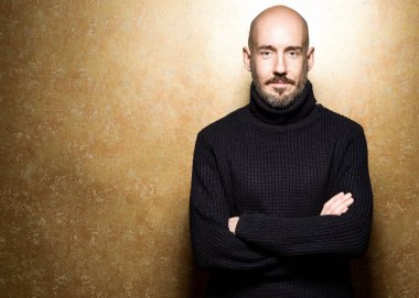 40 yaşındaki adam ayakta bir elma tutan bir siyah kazak moda portre. Yakın çekim. Klasik tarzı. Kel kafası tıraşlı. Boşluk. Stüdyo vurdu