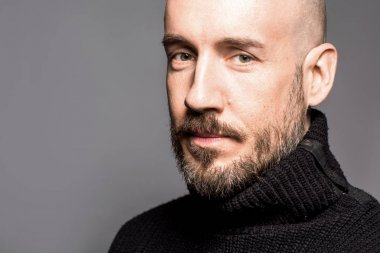 40 yaşındaki adam ayakta bir elma tutan bir siyah kazak moda portre. Yakın çekim. Klasik tarzı. Kel kafası tıraşlı. Boşluk. Stüdyo vurdu