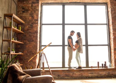 Birbirini seven bir çift hamile, sarılıyor, bebek bekliyor.