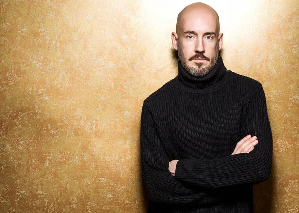 Fashion Portrait of 40-year-old man standing in a black sweater holding an apple. Close up. Classic style. Bald shaved head. Copy-space. Studio shot — Stock Photo, Image