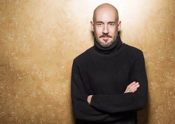 Fashion Portrait of 40-year-old man standing in a black sweater holding an apple. Close up. Classic style. Bald shaved head. Copy-space. Studio shot — Stock Photo, Image